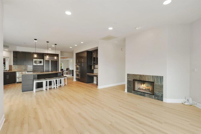 1320 Sleeping Indian Rd, Oceanside, CA 92057 - kitchen featuring appliances with stainless steel finishes, a kitchen breakfast bar, open shelves, light wood-style floors, and recessed lighting