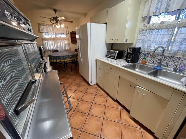 722 N Preston Dr E, Calexico, CA 92231 - kitchen with ceiling fan, a sink, light countertops, freestanding refrigerator, and light tile patterned floors