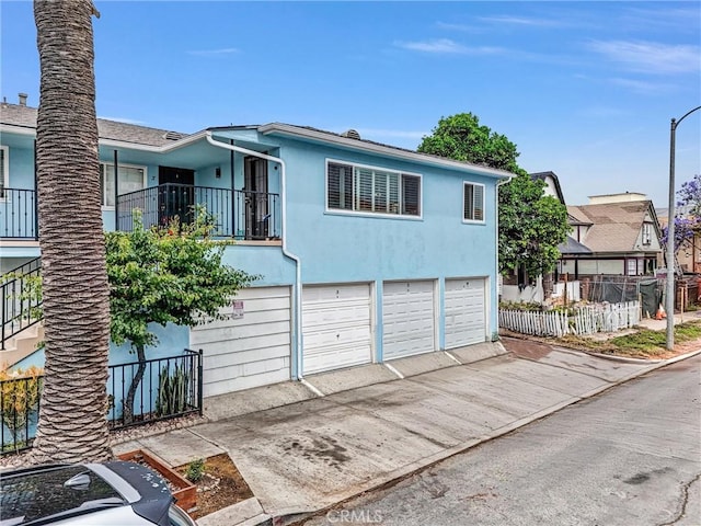 601 Olive Ave Unit L, Long Beach, CA 90802 - view of front of home with a garage, concrete driveway, stucco siding, and a balcony