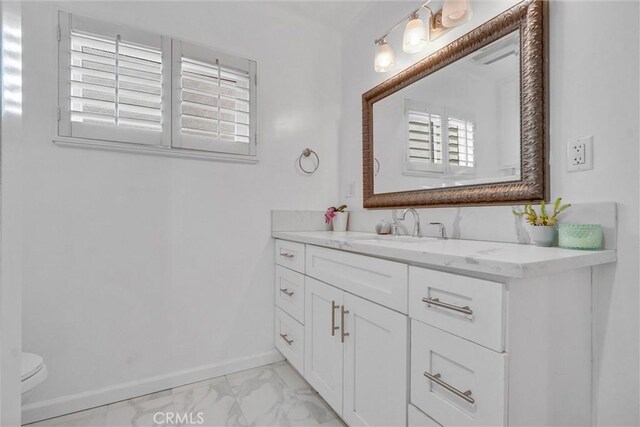 601 Olive Ave Unit L, Long Beach, CA 90802 - bathroom featuring marble look tile flooring, vanity, baseboards, toilet, and healthy amount of natural light