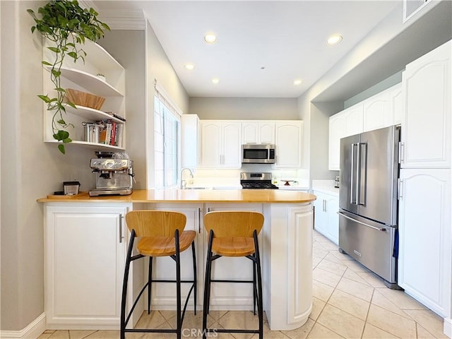 4 Imperial Aisle, Irvine, CA 92606 - kitchen with appliances with stainless steel finishes, a peninsula, a kitchen bar, light countertops, and white cabinets