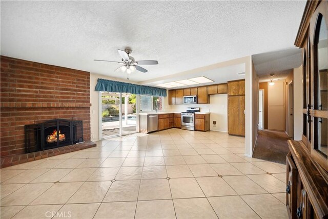 663 Redwood Ave, Upland, CA 91786 - unfurnished living room featuring a textured ceiling, ceiling fan, a fireplace, and light tile patterned flooring