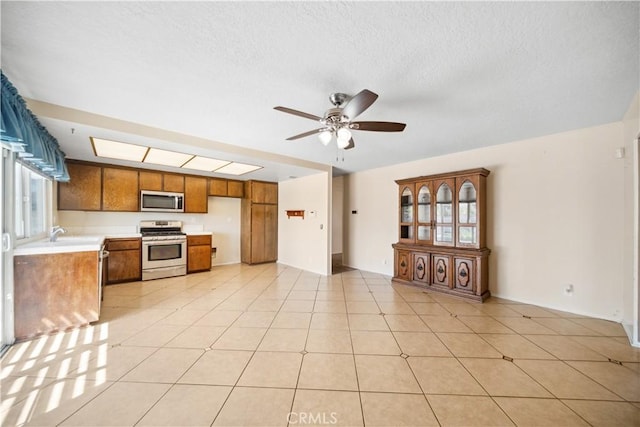 663 Redwood Ave, Upland, CA 91786 - kitchen with appliances with stainless steel finishes, light countertops, brown cabinetry, a ceiling fan, and a textured ceiling