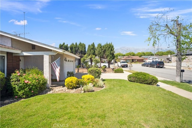 663 Redwood Ave, Upland, CA 91786 - view of green lawn with a mountain view, a garage, driveway, and a residential view