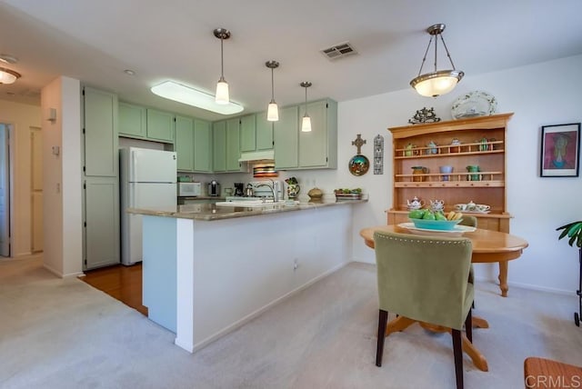 14676 Via Fiesta Unit 2, San Diego, CA 92127 - kitchen featuring freestanding refrigerator, green cabinets, a peninsula, light colored carpet, and under cabinet range hood