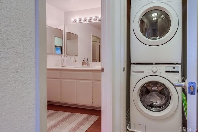 14676 Via Fiesta Unit 2, San Diego, CA 92127 - laundry area with estacked washer and dryer, wood finished floors, a sink, and a textured wall