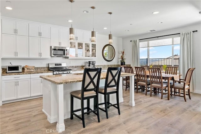 18106 Meridian Ln, Saugus, CA 91350 - kitchen featuring stainless steel appliances, light wood-type flooring, white cabinetry, light stone countertops, and recessed lighting