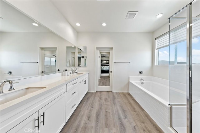 18106 Meridian Ln, Saugus, CA 91350 - full bathroom with a garden tub, double vanity, wood finished floors, recessed lighting, and baseboards