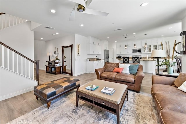 18106 Meridian Ln, Saugus, CA 91350 - living area with light wood-type flooring, recessed lighting, ceiling fan, stairs, and baseboards