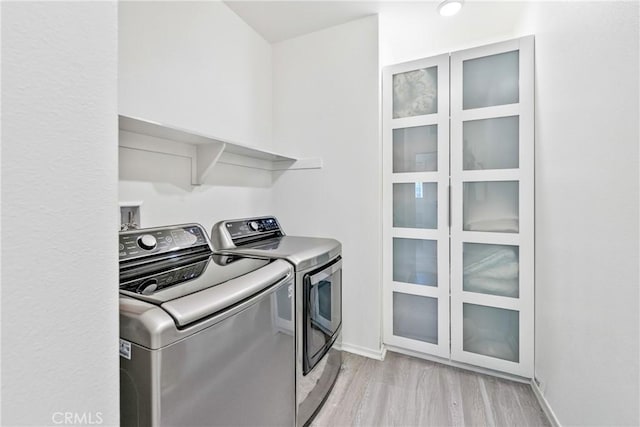 18106 Meridian Ln, Saugus, CA 91350 - washroom featuring washer and clothes dryer, light wood-style floors, and baseboards