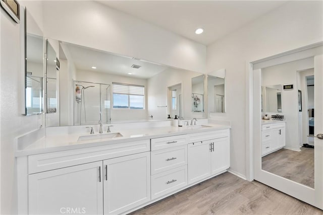 18106 Meridian Ln, Saugus, CA 91350 - bathroom with double vanity, wood finished floors, a stall shower, and recessed lighting