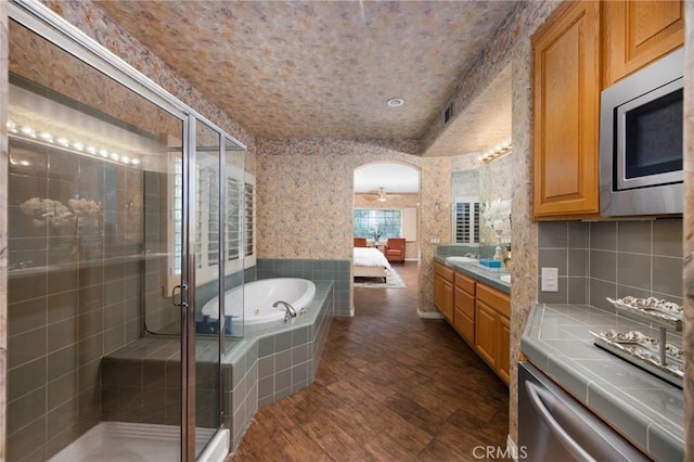 5675 W Overlook Dr, Rancho Cucamonga, CA 91739 - full bathroom with vanity, a garden tub, wood finished floors, and a shower stall