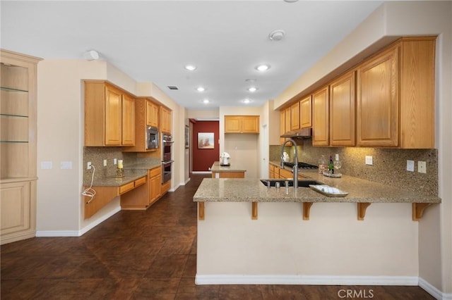 5675 W Overlook Dr, Rancho Cucamonga, CA 91739 - kitchen with a peninsula, light stone counters, stainless steel appliances, a sink, and baseboards