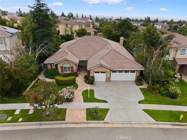 5675 W Overlook Dr, Rancho Cucamonga, CA 91739 - view of front of house featuring a garage, a tiled roof, driveway, a residential view, and a chimney