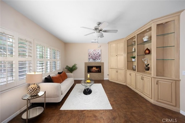 5675 W Overlook Dr, Rancho Cucamonga, CA 91739 - living room featuring a ceiling fan, baseboards, and a lit fireplace