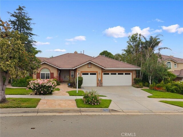 5675 W Overlook Dr, Rancho Cucamonga, CA 91739 - ranch-style house featuring a tiled roof, an attached garage, driveway, a chimney, and stucco siding