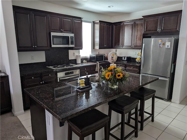 753 Huron Pl, Claremont, CA 91711 - kitchen featuring appliances with stainless steel finishes, light tile patterned flooring, a kitchen breakfast bar, and dark brown cabinets