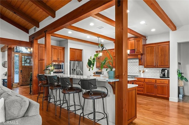 133 Valley Ridge Dr, Paradise, CA 95969 - kitchen with appliances with stainless steel finishes, decorative backsplash, a kitchen bar, light wood finished floors, and recessed lighting