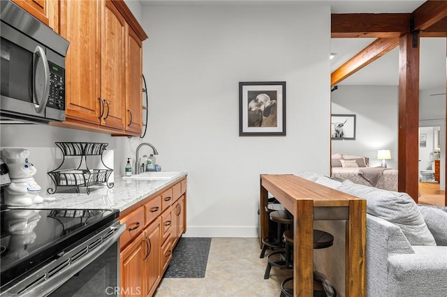 133 Valley Ridge Dr, Paradise, CA 95969 - kitchen with stainless steel microwave, electric range oven, brown cabinetry, light stone countertops, and light tile patterned flooring