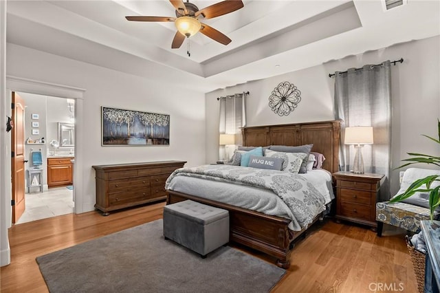133 Valley Ridge Dr, Paradise, CA 95969 - bedroom with a tray ceiling, light wood-type flooring, connected bathroom, and a ceiling fan