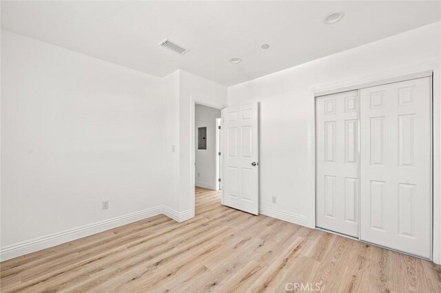 941 E 97th St, Los Angeles, CA 90002 - unfurnished bedroom featuring light wood-style flooring, baseboards, a closet, recessed lighting, and electric panel