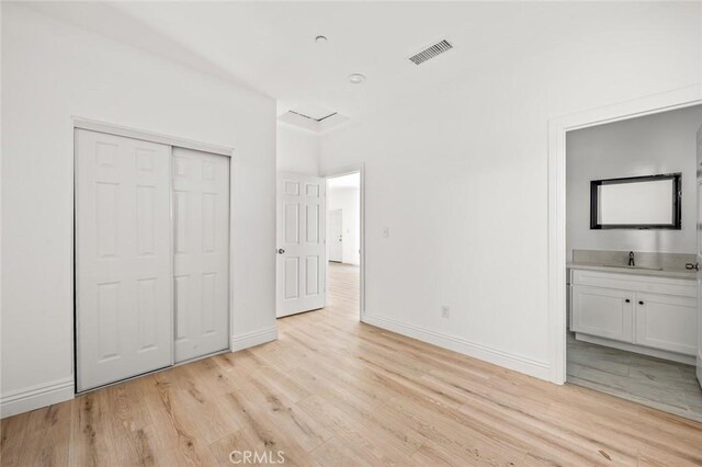 941 E 97th St, Los Angeles, CA 90002 - unfurnished bedroom with light wood-style floors, baseboards, and a closet
