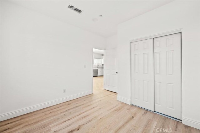 941 E 97th St, Los Angeles, CA 90002 - unfurnished bedroom featuring light wood-style flooring, a closet, and baseboards