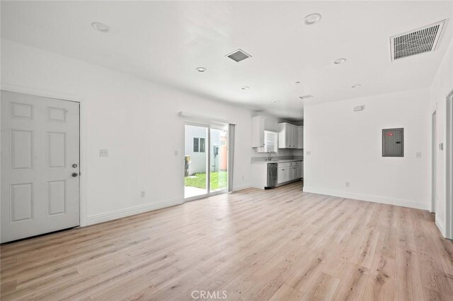 941 E 97th St, Los Angeles, CA 90002 - unfurnished living room featuring light wood-type flooring, baseboards, recessed lighting, electric panel, and a sink