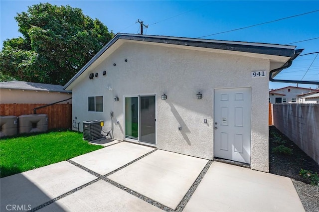 941 E 97th St, Los Angeles, CA 90002 - rear view of house featuring stucco siding, central AC unit, and a fenced backyard