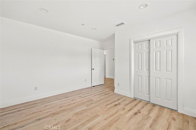 941 E 97th St, Los Angeles, CA 90002 - unfurnished bedroom with light wood finished floors, baseboards, a closet, and recessed lighting