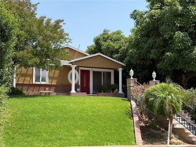 431 W M St, Colton, CA 92324 - view of front of home featuring stucco siding, a front lawn, stairway, and brick siding
