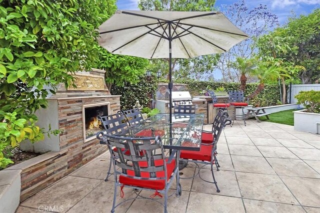 8 Marston Ln, Ladera Ranch, CA 92694 - view of patio featuring an outdoor stone fireplace and outdoor dining space