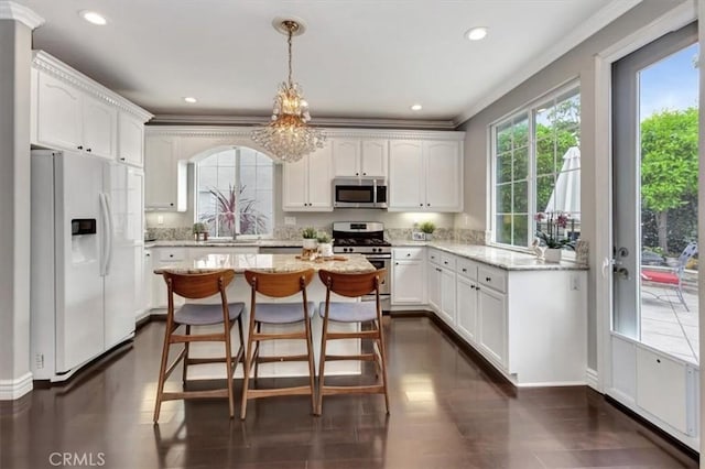 8 Marston Ln, Ladera Ranch, CA 92694 - kitchen with appliances with stainless steel finishes, plenty of natural light, white cabinets, ornamental molding, and recessed lighting