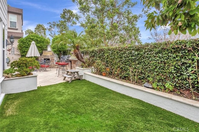 8 Marston Ln, Ladera Ranch, CA 92694 - view of grassy yard featuring an outdoor stone fireplace and a patio area
