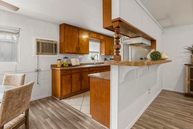 642 Carlsbad St, Spring Valley, CA 91977 - kitchen featuring brown cabinets, light wood-type flooring, a sink, a peninsula, and baseboards