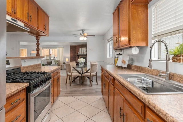 642 Carlsbad St, Spring Valley, CA 91977 - kitchen featuring stainless steel gas range oven, a sink, brown cabinets, ceiling fan, and plenty of natural light