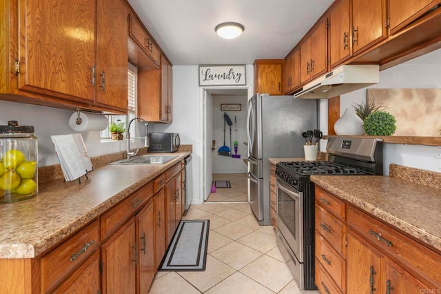 642 Carlsbad St, Spring Valley, CA 91977 - kitchen featuring stainless steel appliances, under cabinet range hood, a sink, brown cabinets, and light tile patterned floors