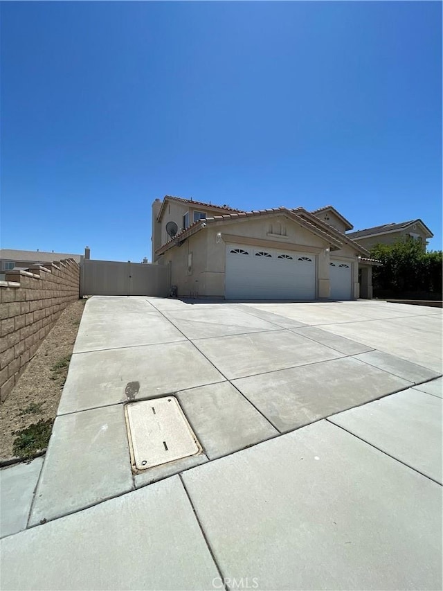 37000 Sabal Ave, Palmdale, CA 93552 - view of front of home featuring a garage, concrete driveway, a tiled roof, and stucco siding