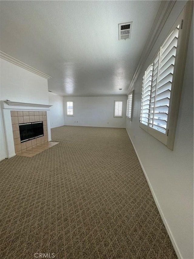 37000 Sabal Ave, Palmdale, CA 93552 - unfurnished living room featuring carpet floors, a tile fireplace, ornamental molding, plenty of natural light, and a textured ceiling
