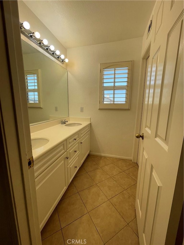 37000 Sabal Ave, Palmdale, CA 93552 - bathroom featuring healthy amount of natural light, double vanity, tile patterned floors, baseboards, and a textured ceiling