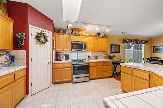 2860 Cathedral Ln, Arroyo Grande, CA 93420 - kitchen featuring stainless steel appliances, track lighting, tile countertops, and backsplash