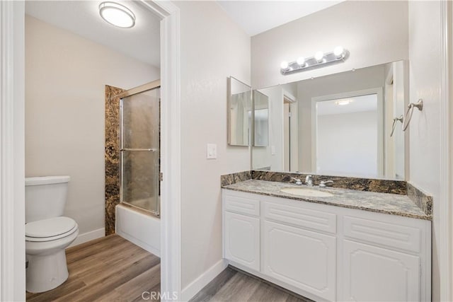 27505 Ventura Dr, Cathedral City, CA 92234 - full bathroom with wood finished floors, vanity, toilet, baseboards, and combined bath / shower with glass door