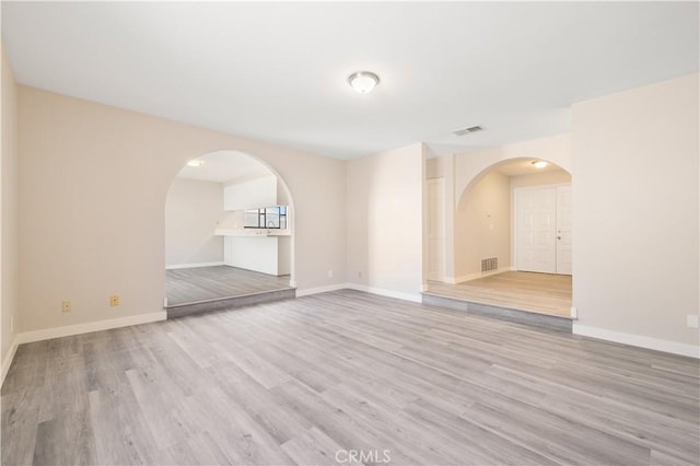 27505 Ventura Dr, Cathedral City, CA 92234 - empty room featuring arched walkways, wood finished floors, and baseboards