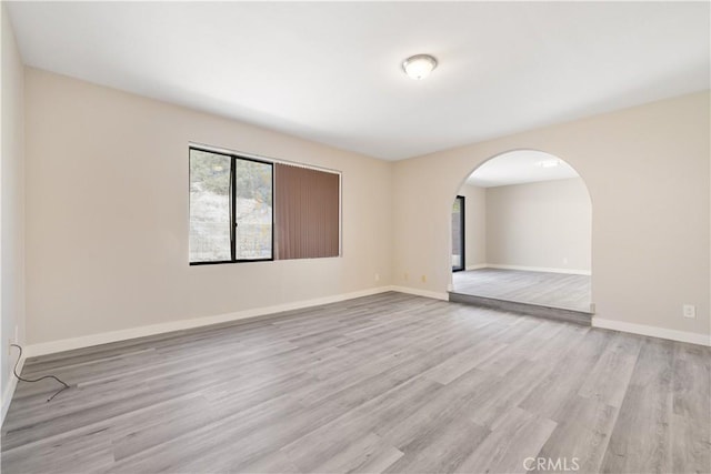 27505 Ventura Dr, Cathedral City, CA 92234 - empty room with light wood-style flooring, arched walkways, and baseboards