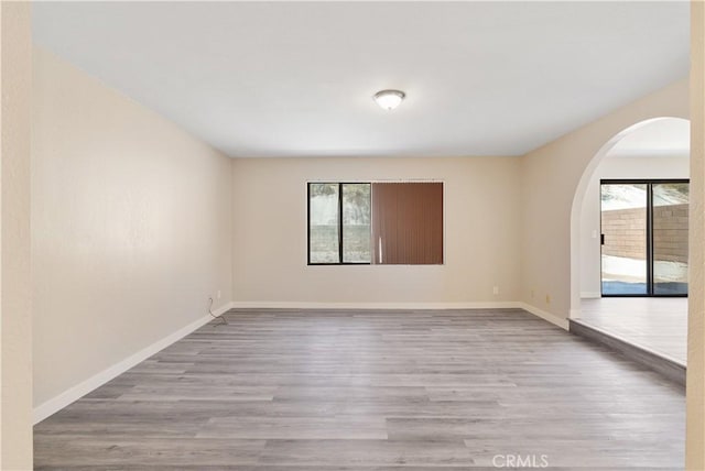 27505 Ventura Dr, Cathedral City, CA 92234 - unfurnished room with healthy amount of natural light, arched walkways, wood finished floors, and baseboards