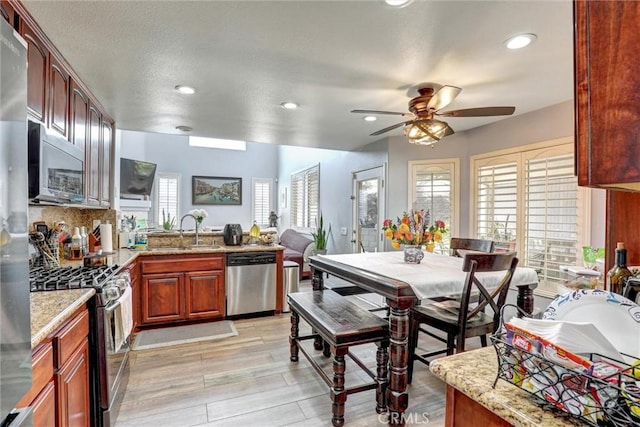 3506 Belvedere Way, Corona, CA 92882 - kitchen with appliances with stainless steel finishes, recessed lighting, ceiling fan, a peninsula, and light stone countertops