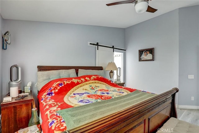 3506 Belvedere Way, Corona, CA 92882 - bedroom with light wood finished floors, a barn door, and a ceiling fan