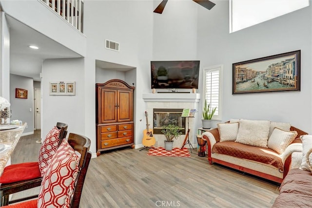 3506 Belvedere Way, Corona, CA 92882 - living area with ceiling fan, wood finished floors, a towering ceiling, and a tiled fireplace