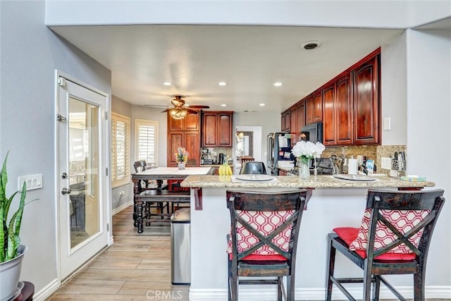 3506 Belvedere Way, Corona, CA 92882 - kitchen featuring black microwave, a breakfast bar area, tasteful backsplash, a peninsula, and recessed lighting