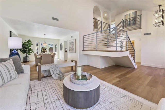 13621 Fairmont Way, Tustin, CA 92780 - living room featuring stairs, wood finished floors, high vaulted ceiling, baseboards, and a chandelier